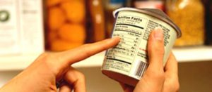 Producto entre las manos de un consumidor que revisa información en el etiquetado