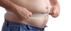Hombre midiéndose el abdomen con cinta métrica