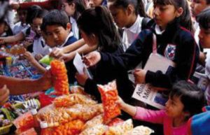 Niños y niñas comprando en un puesto afuera de la escuela