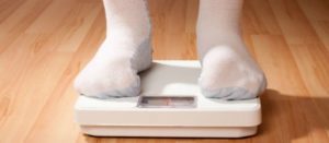 Pies con calcetas de un niño sobre una báscula para medir su peso corporal