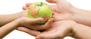 El planeta Tierra en forma de manzana que pasan de las manos de un adulto a las manos de un niño