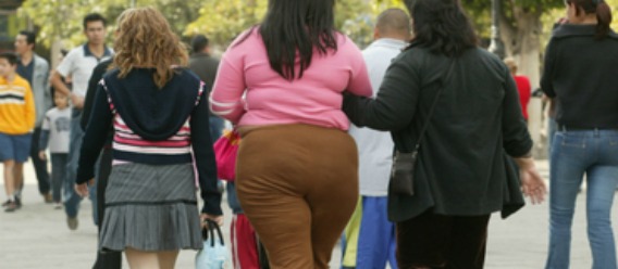 Personas de espaladas con sobrepeso u obesidad caminando por la calle