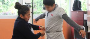 Maestra midiendo la cintura de un niño en escuela de Oaxaca, México