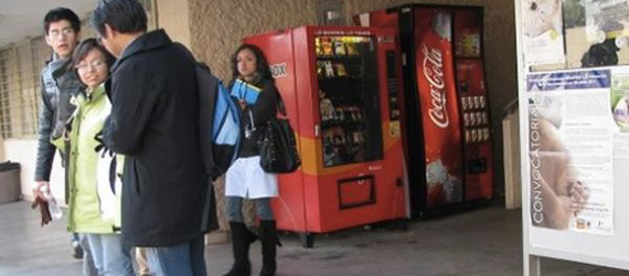 Máquinas expendedoras de alimentos y bebidas chatarra en una escuela de México, junto a un grupo de estudiantes