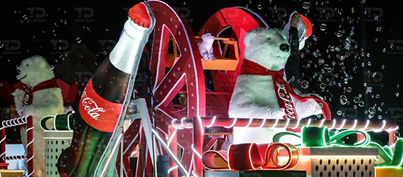 Camión alegórico iluminado de una de las Caravanas Navideñas Coca-Cola, con la botarga de un gran oso polar y una gran botella de la bebida de Coca-Cola
