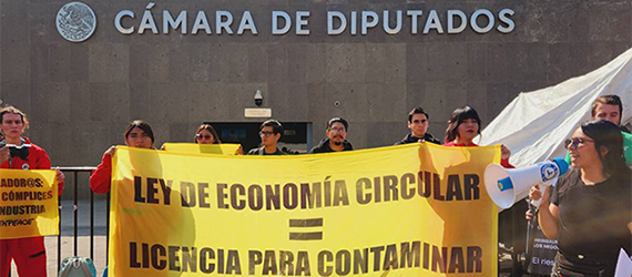 Acción de organizaciones civiles frente a la Cámara de Diputados en contra de la aprobación “fast track” y “en lo oscurito” de la Ley de Economía Circular, portando una manta con las leyendas: LEY DE ECONOMÍA CIRCULAR=LICENCIA PARA CONTAMINAR y QUEMAR BASURA MATA